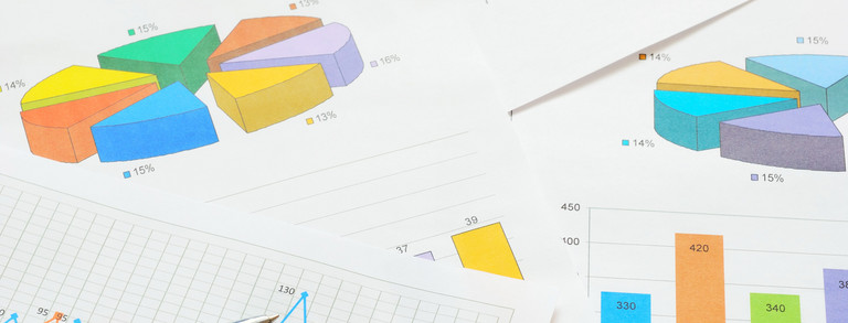 Bunte Kreis- und Balkendiagramme und ein Graph im Detail auf verschiedenen Seiten, die übereinander liegen. 