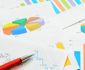 Bunte Kreis- und Balkendiagramme und ein Graph im Detail auf verschiedenen Seiten, die übereinander liegen. 