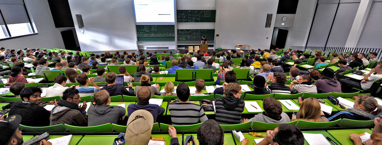 Students sit in a lecture hall in the seminar building at the Campus North.
